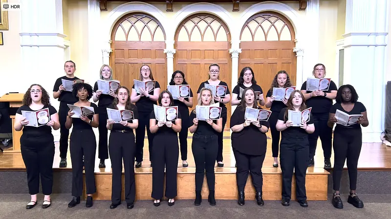 The Ursinus College Singers on the Bomberger Auditorium stage beneath its gothic arches