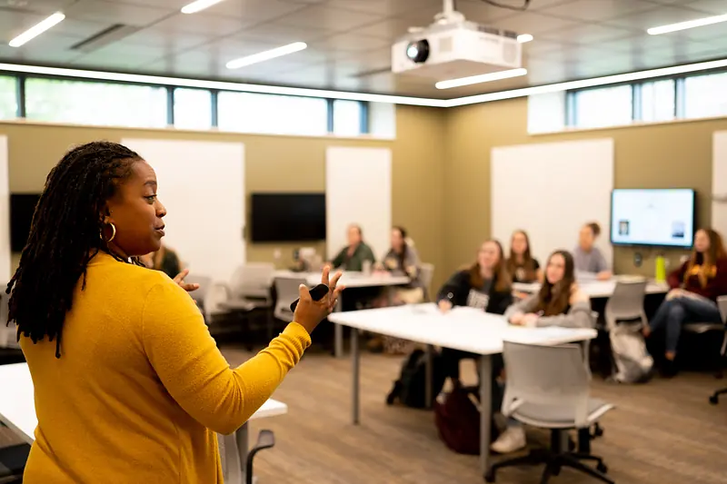 A presenter leading a session in a campus meeting room