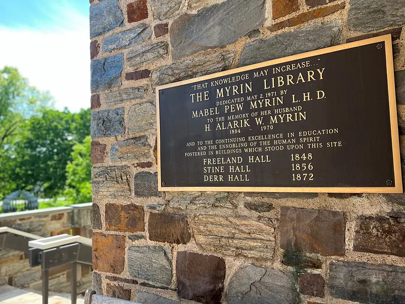 The dedication plaque on the stone exterior of Myrin Library