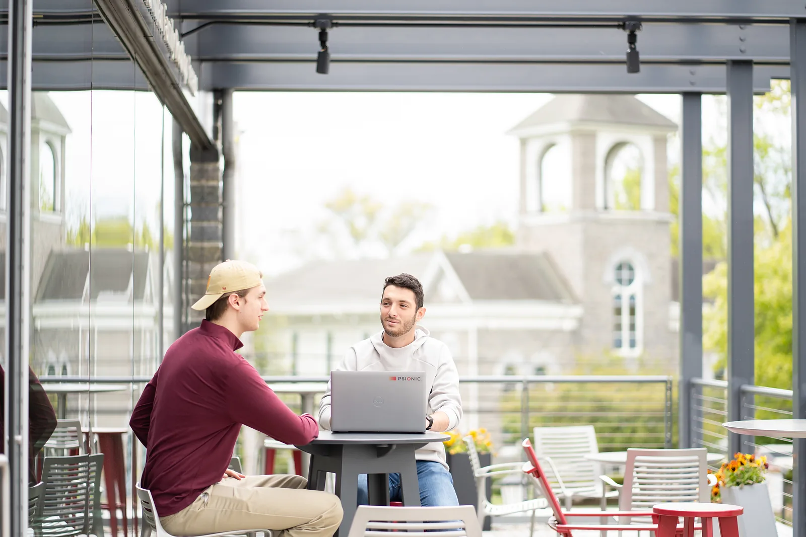 The Commons terrace with its glass doors opened toward the campus