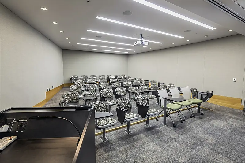 Rows of chairs with tablet arms in Pfeiffer Wing Classroom 016, seen from the lectern