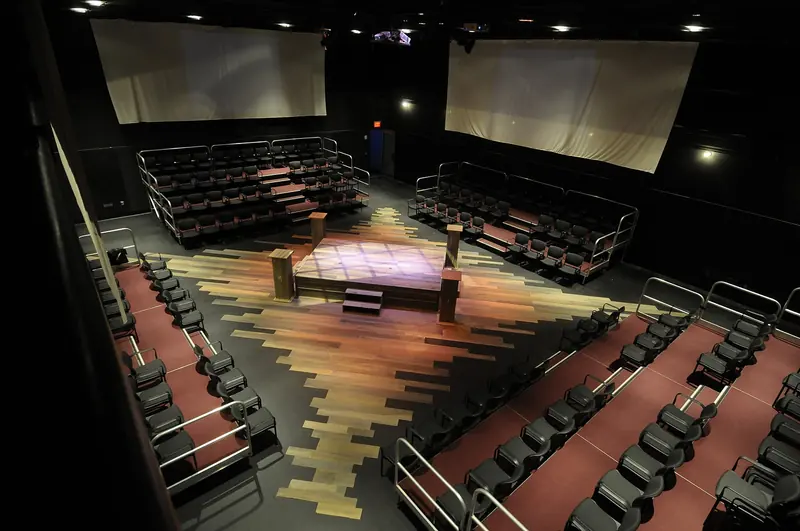 The Black Box Theater set in the round, with seating risers on all four sides of a raised stage