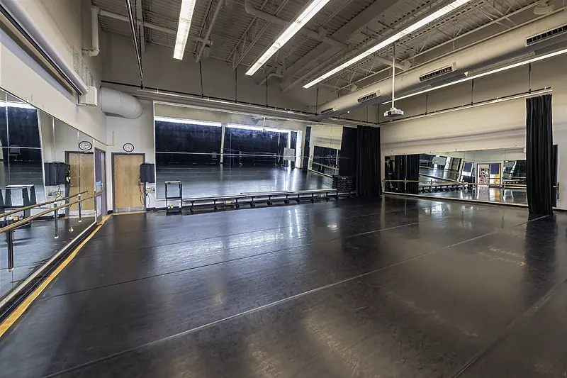 The dark studio floor, mirrored walls and barres of the Helfferich Dance Studio